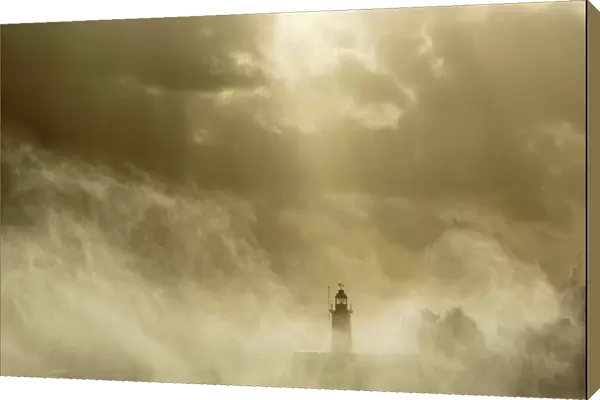 Waves crash against a lighthouse at Newhaven on the Sussex coast in southern England