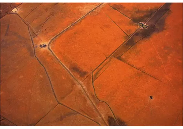 An aerial view of small dams containing water are seen in dry paddocks located north-west