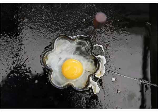 A fried egg is seen on a grill in a roadside snack cafe along the A49 near Tittensor