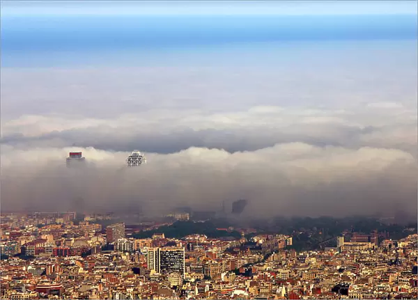 An unusual fog settles over Barcelonas city coastline