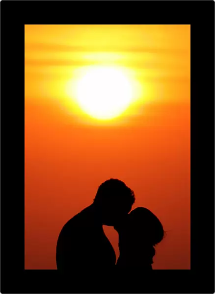 Western tourists kiss during sunset in Bali