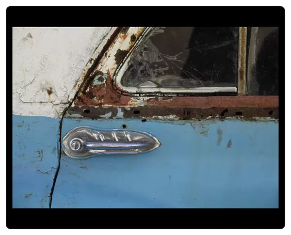 A door of a rusty vintage car is pictured in Havana