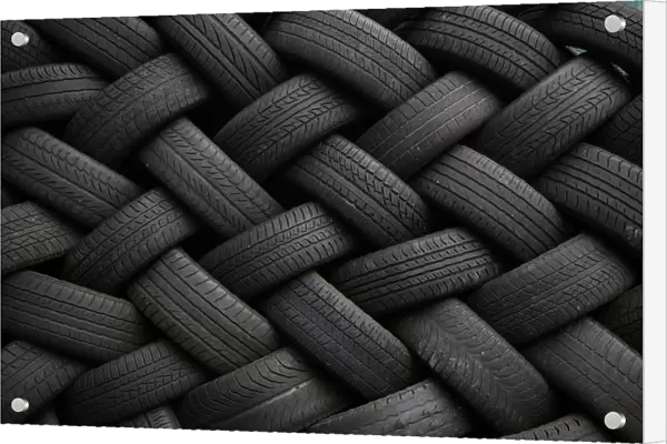 Used car tires form a pattern as they are seen stacked outside an automotive shop in East Dulwich