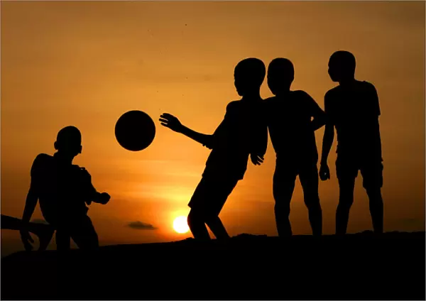 Children playing soccer are silhouetted at sunset in Nigerias main city of Lago