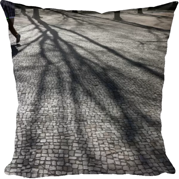 Two pedestrians cast their shadows during a sunny day in Berlin