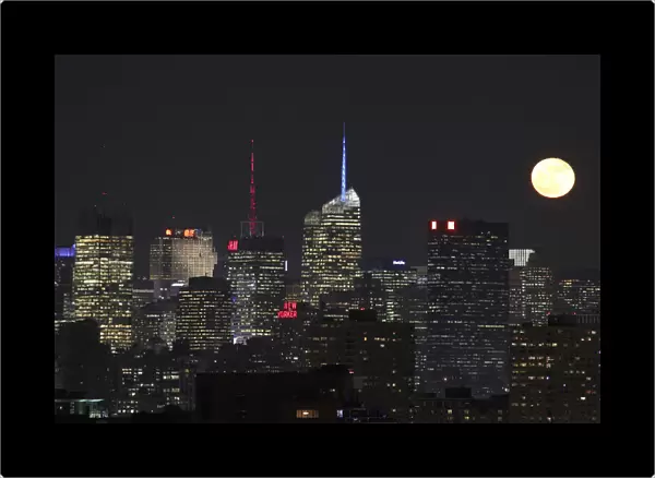 Moon rises behind the skyline of New York, as seen from Jersey City