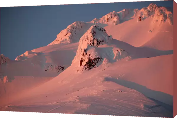 At sunset, climbers and rescue personnel descend Mount Hood