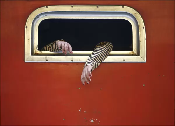 The hands of a passenger on board a train are pictured at the train station in Jakarta