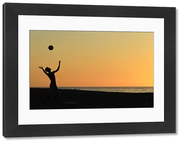 A volleyball player serves at Moonlight Beach in Encinitas, California