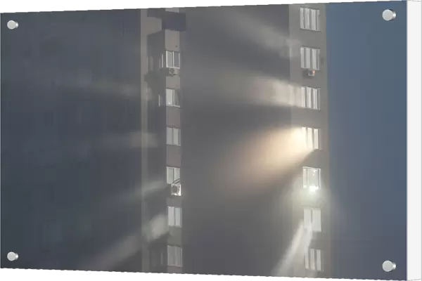 Sunlight reflects from windows of an apartment building on a foggy autumn day in Kiev
