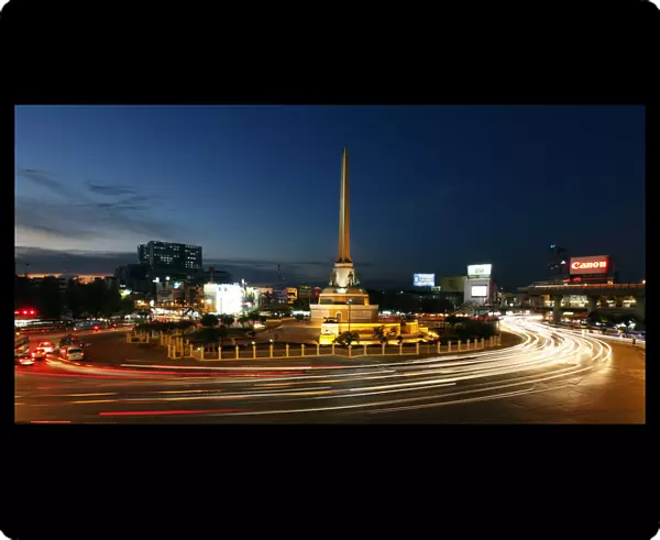 Bangkoks Victory Monument is seen lit as cars go past its roundabout