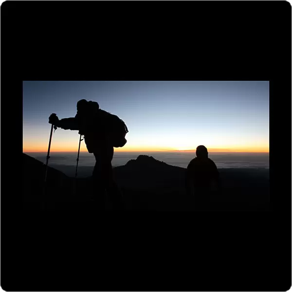 Climbers walk up the steep gravel and scree slope leading to the summit of Tanzania s