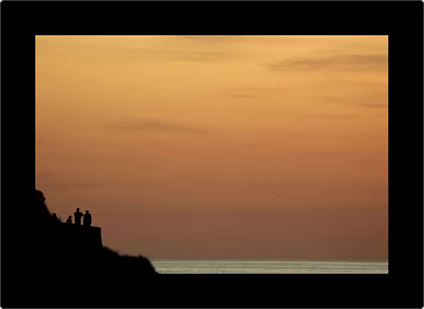 People look over Atlantic sea from a viewpoint at sunset ahead of the G7 summit in