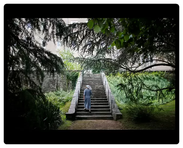A sister, member of the Clarisses community, walks in the garden of Saint Clare Monastery