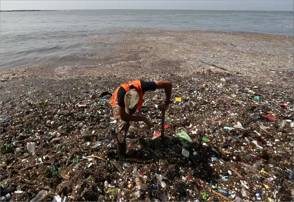A soldier pauses while cleaning plastic and other debris on the shores of Montesinos