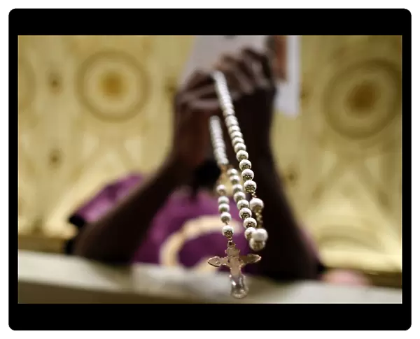 A person prays with a rosary as Pope Francis leads the Holy Rosary at the Saint Mary