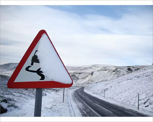 A slippery road warning sign is covered in snow on the A93 in Perthshire, Scotland