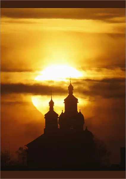 The sun rises above an Orthodox Church in the town of Novogrudok