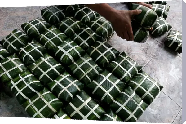 A resident arranges a pile of banh chung, or rice cakes, ahead of Tet