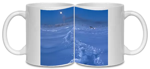 A car drives through the snow at night near Vostochnaya meteorological station