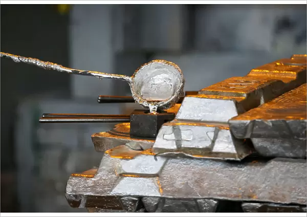 A worker takes a sample of molten alumnium in a shop of Kazakh mining company Eurasian