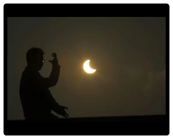A man practices taichi during an eclipse at the Bund along the Huangpu River in Shanghai