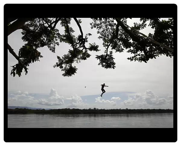 A boy jumps from a tree into Caura river in Maripa in the southern state of Bolivar