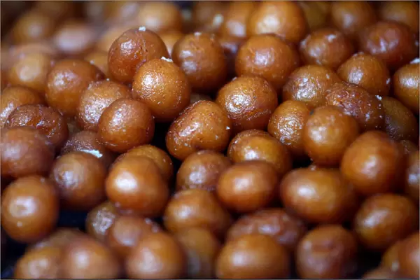 Gulab jamuns (traditional Indian sweet) are on display for sale at a sweets shop in
