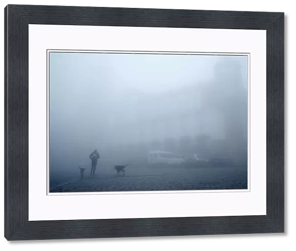 A man walks on a street on a foggy day in Sighnaghi