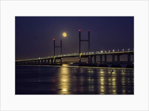 View of road bridge over river at twilight with full moon, viewed from Divers Rock at Sudbrook, Second Severn Crossing