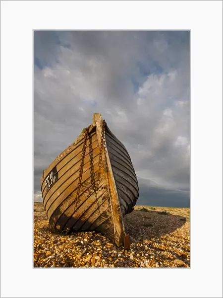Abandoned fishing boat on shingle beach, Dungeness, Kent, England, April