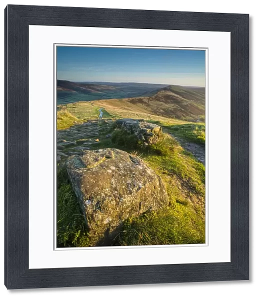 View of rocks beside path on moorland at dawn, looking from Mam Tor to Hollins Cross, High Peak District