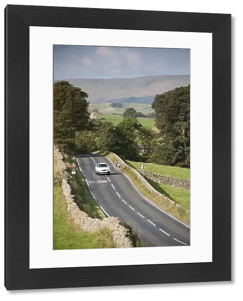 Country road with car passing cyclists, near Hawes, Wensleydale, Yorkshire Dales N. P