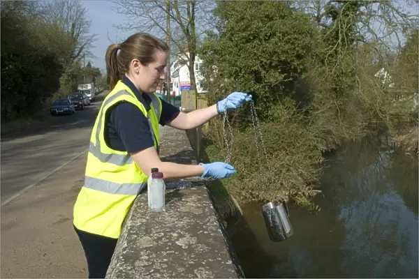 Water quality scientist from Thames Water, taking samples to be tested for traces of metaldehyde, carbetamide and propyzamide, River Cherwell, Cropredy Bridge, Oxfordshire, England, march