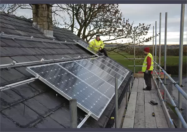 Solar power, photovoltaic panels being fitted on house roof, near Chipping, Lancashire, England, november