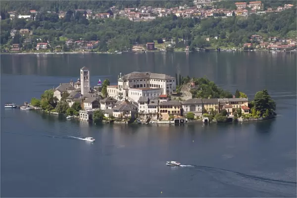 View of lake island and water taxis, Isola San Giulio, Lake Orta, Piedmont, Italy, May