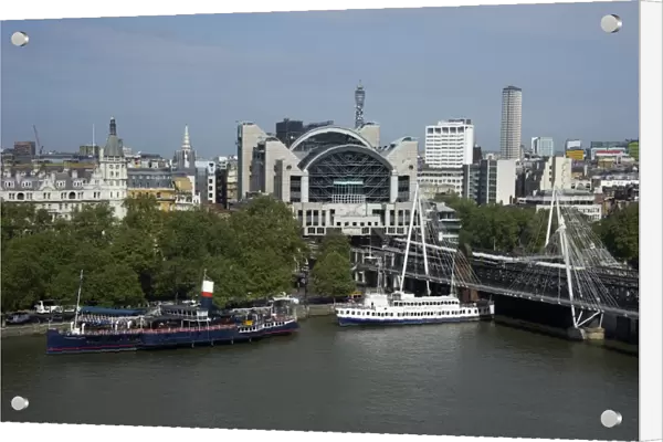 View from London Eye of city river with boats and Charing Cross railway station, Hungerford Bridge, River Thames