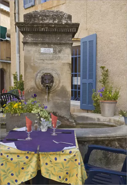 France, Provence, Lourmarin. Outdoor cafe tables wait for customers