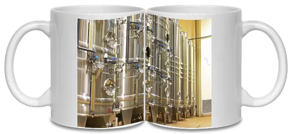 Stacks of stainless steel fermentation vats in various sizes and with cooling systems
