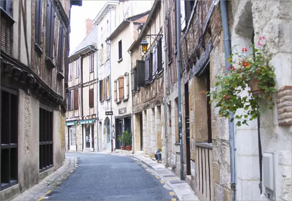 A curving street in the old town with old stone and wooden beam houses. Bergerac