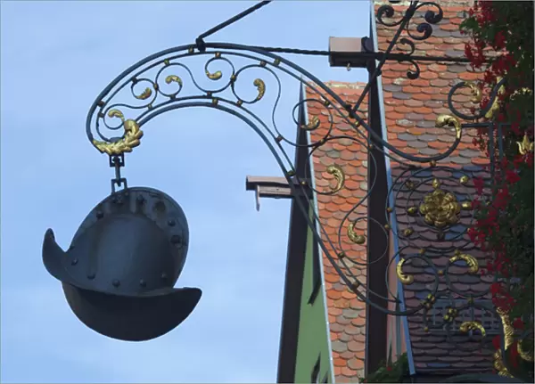 Europe, Germany, Rothenburg. A medieval helmet sign hangs in front of an ironworks shop