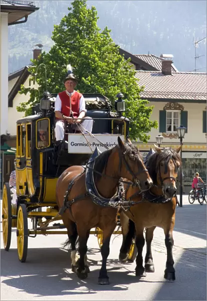 Street scene with a horse drawn stage coach in the alpine village of Garmisch, Germany