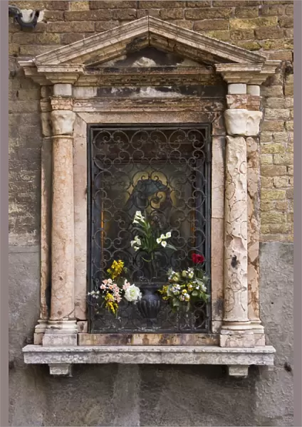 Europe, Italy, Venice. Devotional niche to Virgin Mary on street wall. Credit as
