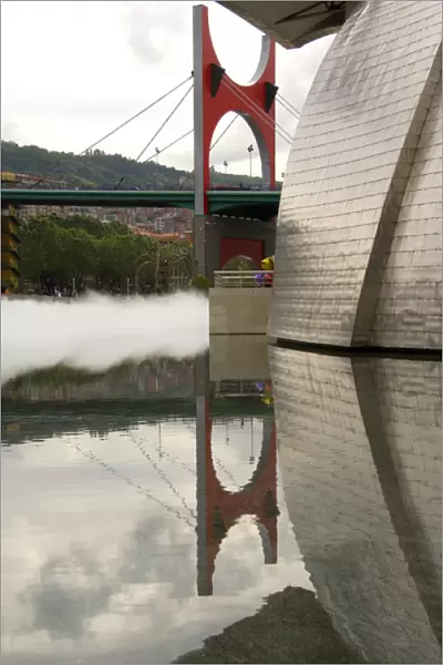 Spain, Bilbao. Guggenheim Museum with mist & bridge reflections