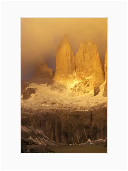 Sunrise with golden clouds on Torres del Paine in Patagonia region of Chile