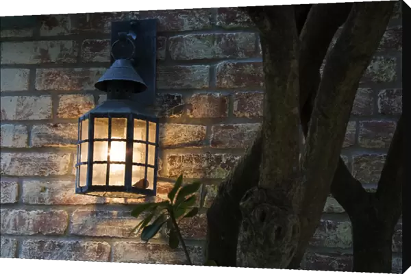 North America, USA, Georgia, Savannah. Lantern on a brick wall of a home in historical