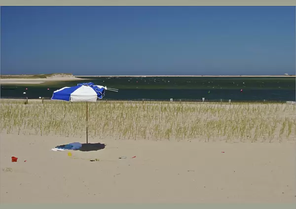 North America, USA, Massachusetts, Chatham. An umbrella and pails on the beach