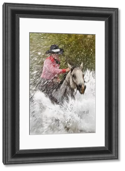 Slow motion view of cowgirl riding through water, Montana