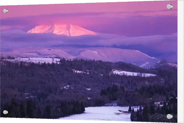 Sunrise on a snow covered landscape with Mt Hood peeking through clouds, as viewed