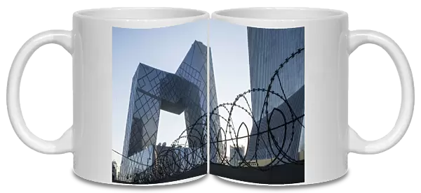 China, Beijing, Barbed wire surrounds perimeter of gleaming steel and glass CCTV